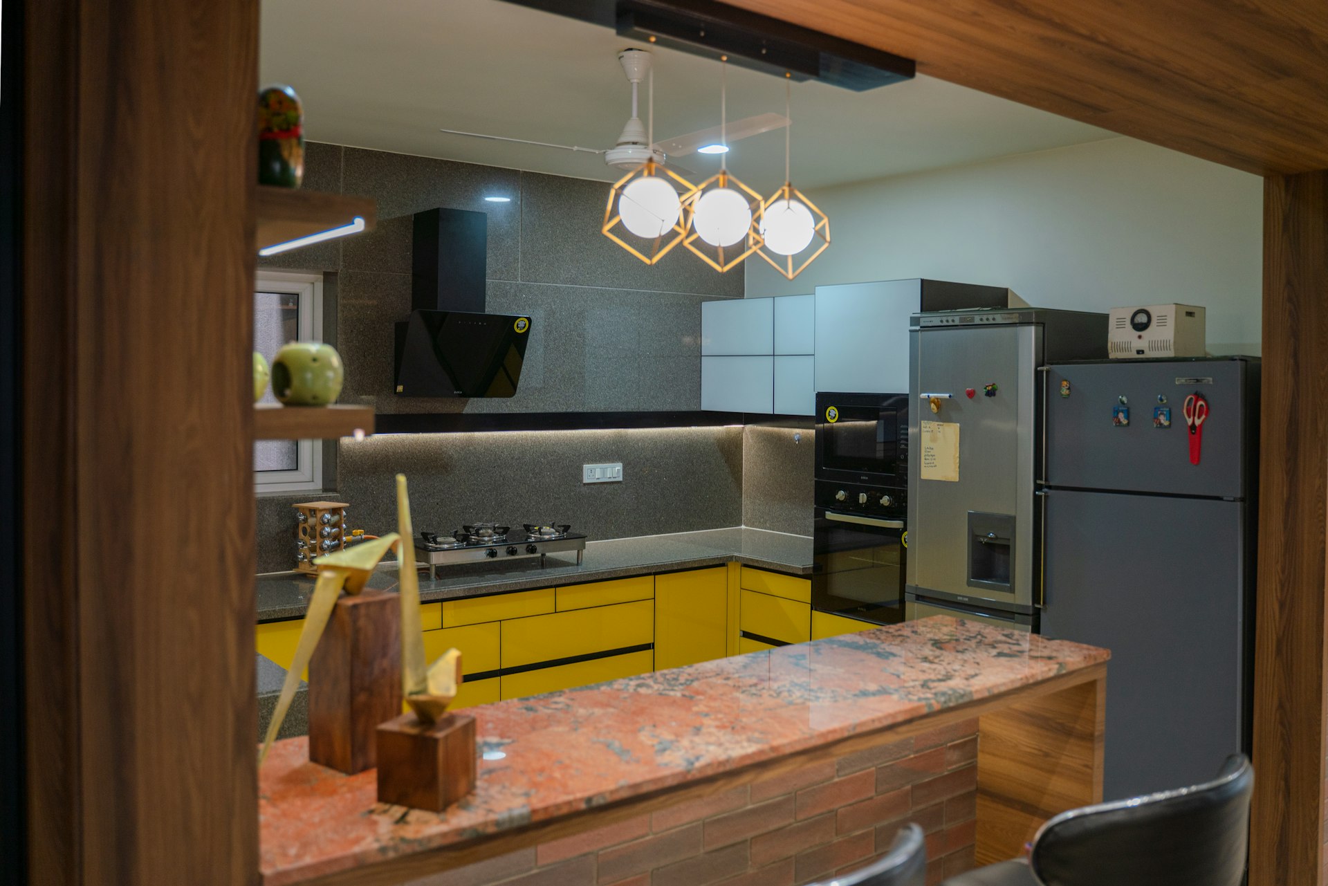 Modern kitchen design with yellow cabinets and granite counter.
